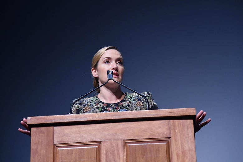 Kate Winslet stands at a podium